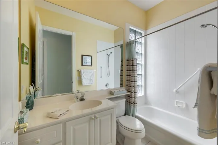 Full bathroom featuring vanity, shower / bath combo with shower curtain, and toilet