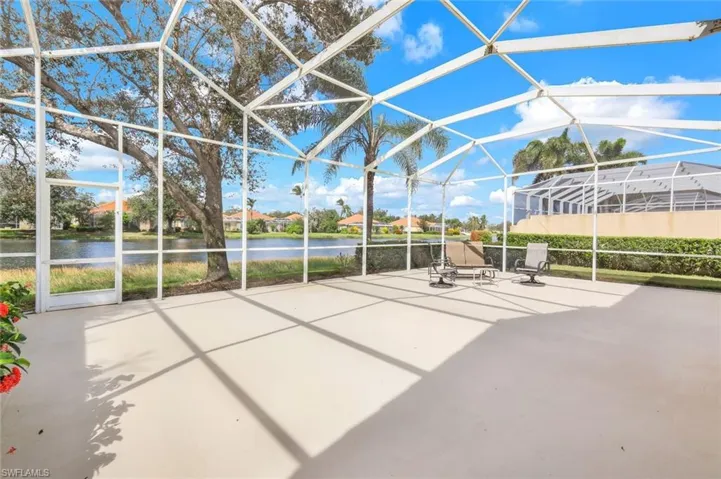 View of patio featuring a water view and glass enclosure