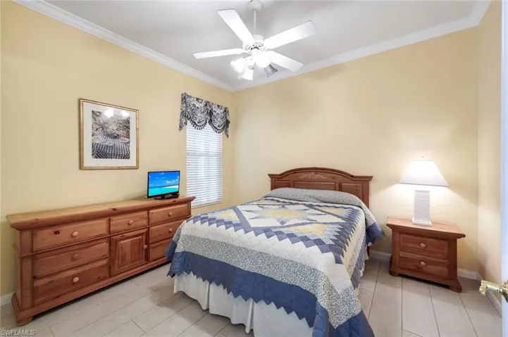 Bedroom featuring ornamental molding, light hardwood / wood-style floors, and ceiling fan