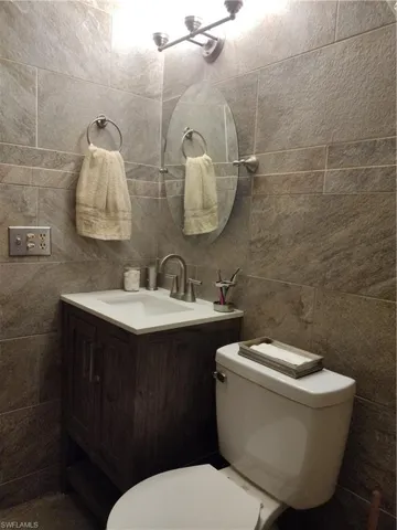vanity, tile walls, and backsplash