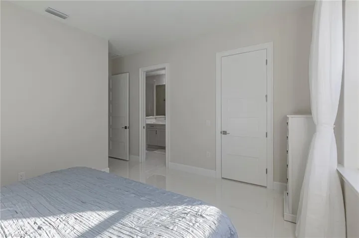 Bedroom featuring ensuite bathroom and light tile patterned floors