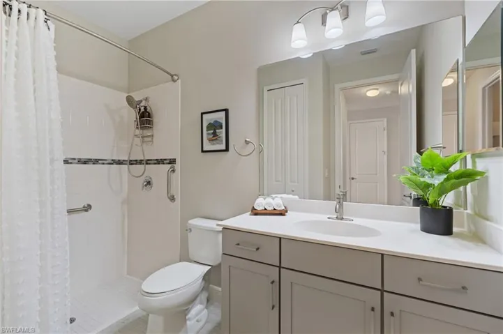Bathroom with walk in shower, vanity, and toilet