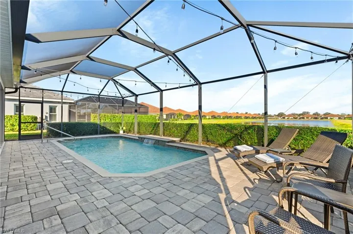 View of pool with a lanai and a patio