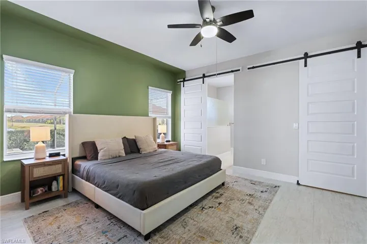 Bedroom featuring ceiling fan and a barn door
