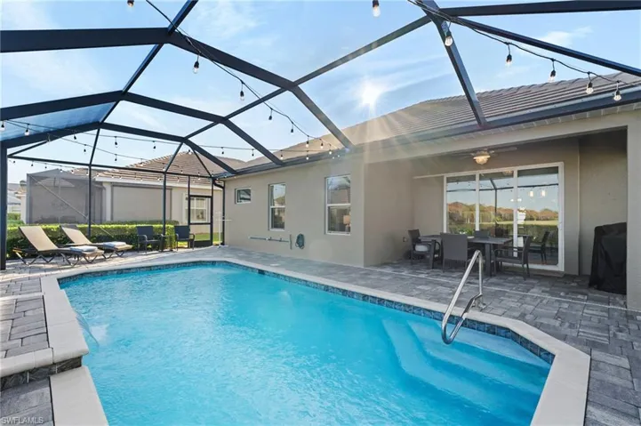 View of swimming pool featuring a lanai, a patio, and ceiling fan