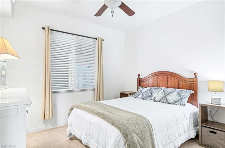 Guest bedroom with lighted ceiling fan.
