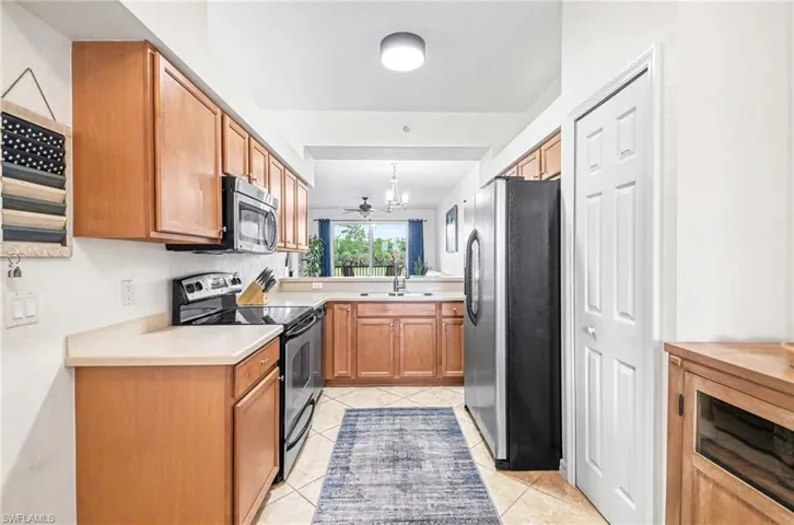 Well-appointed fully appliance kitchen with wood cabinetry and convenient pantry closet.
