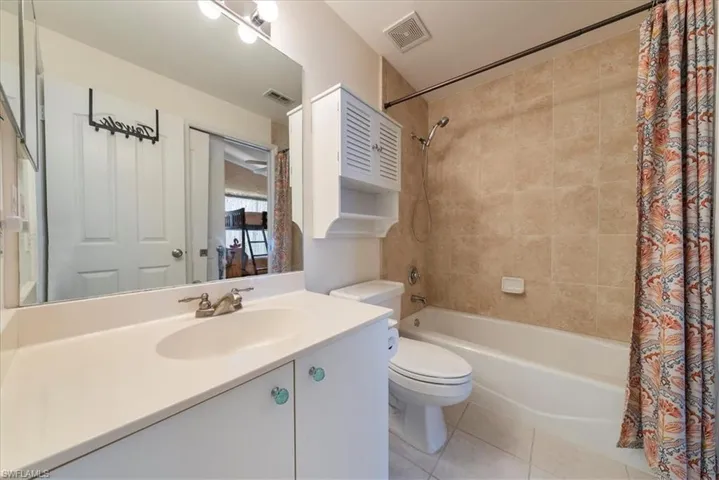 Bathroom featuring shower / bath combo, tile patterned floors, and vanity