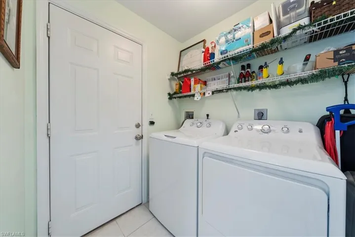 Laundry room featuring independent washer and dryer and light tile patterned floors