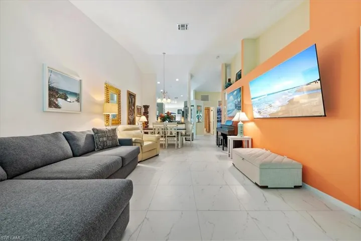 Living room featuring marble finish floors and a chandelier