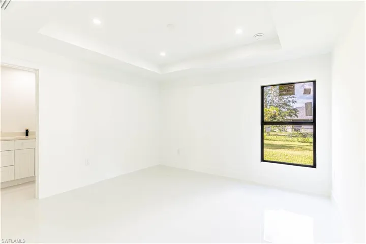 Empty room featuring recessed lighting and a raised ceiling