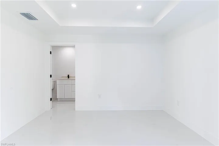 Spare room with a tray ceiling and recessed lighting