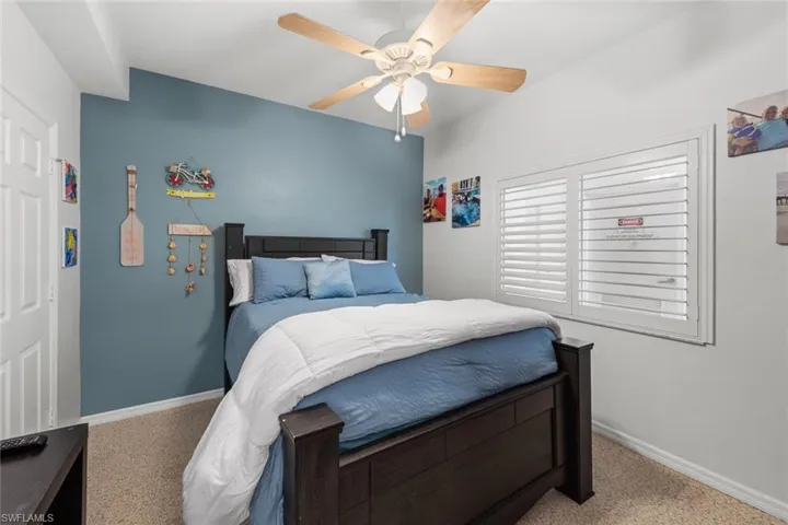 Bedroom with light colored carpet and ceiling fan
