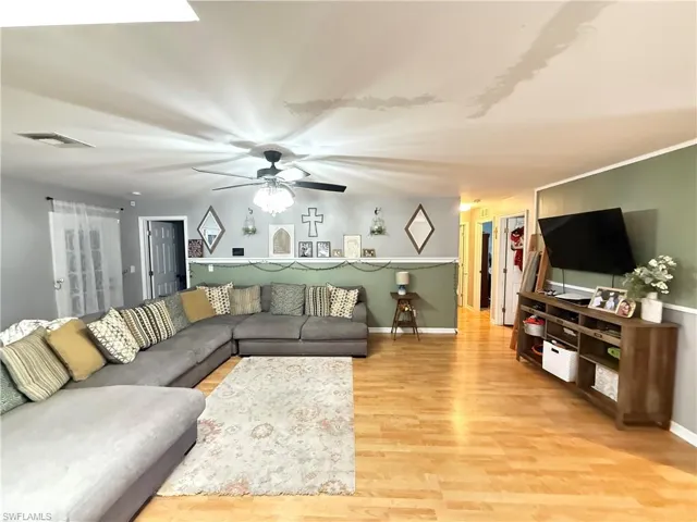 Living room featuring light wood finished floors and ceiling fan