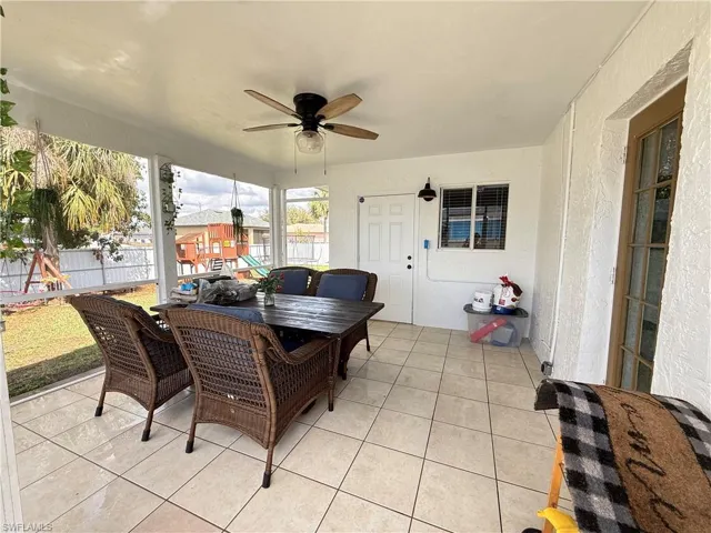Sunroom / solarium with outdoor dining area, ceiling fan, and a patio