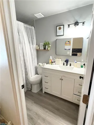 Bathroom featuring vanity, a shower with shower curtain, and light wood finished floors
