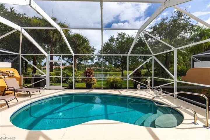View of swimming pool with a water view, a lanai, and a patio