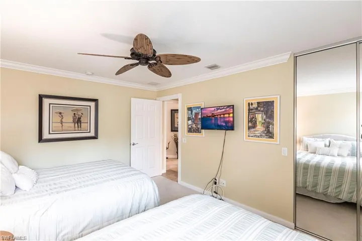 Carpeted bedroom featuring ornamental molding and ceiling fan