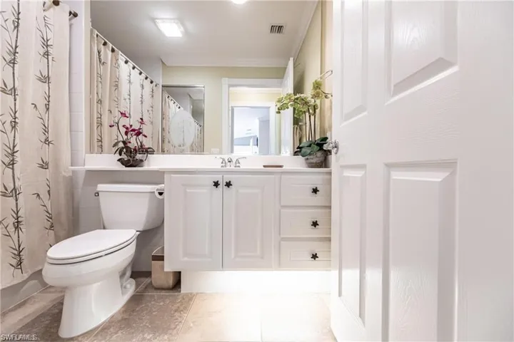 Bathroom with vanity, toilet, and a shower with shower curtain