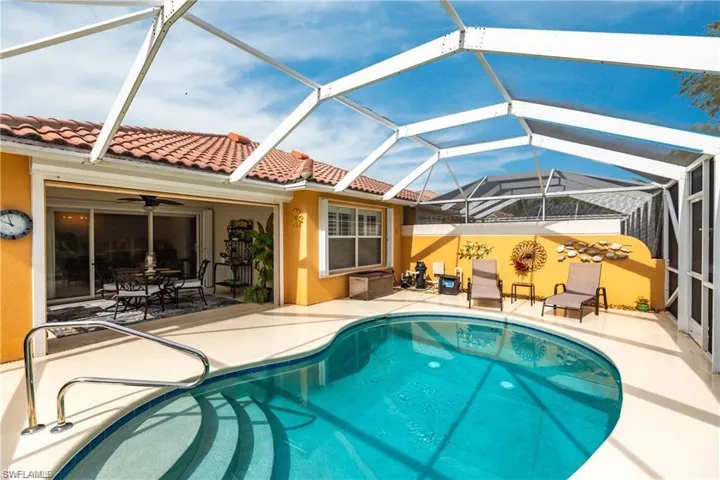View of pool featuring a patio area and glass enclosure