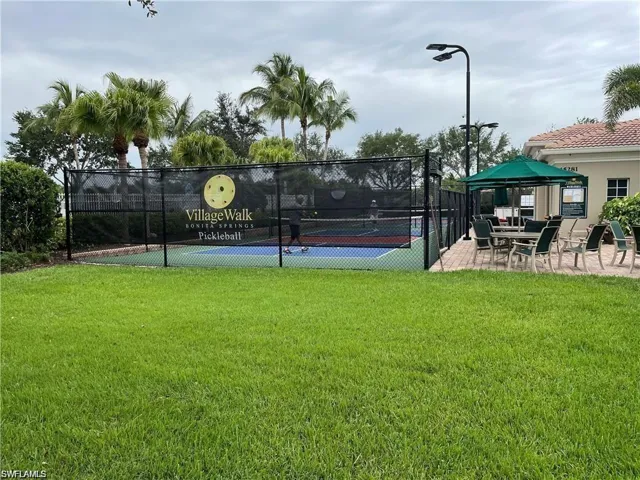 View of tennis court with a yard and a gazebo