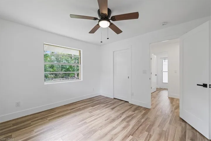 Unfurnished guest bedroom with light wood finished floors and a ceiling fan