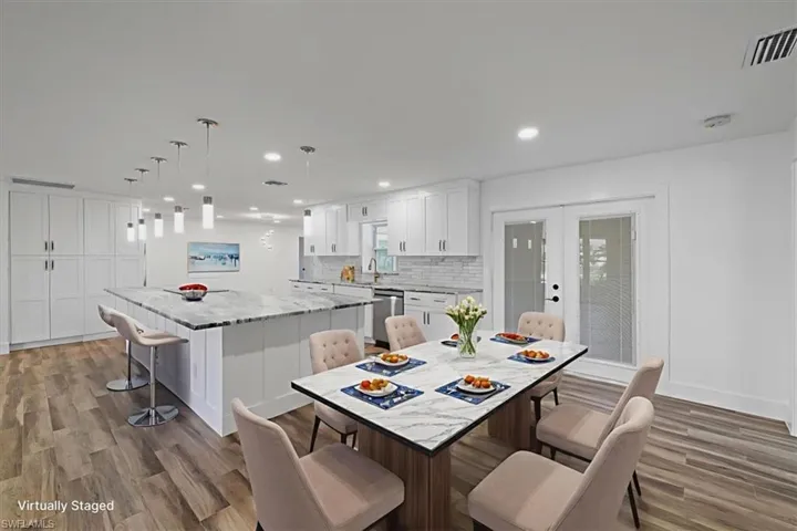 Dining room featuring light wood finished floors, recessed lighting, and french doors
