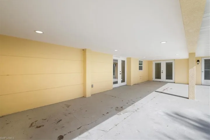 Back of property featuring french doors, stucco siding, and a tile roof