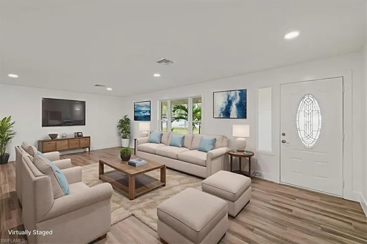 Living room virtualy staged featuring recessed lighting and light wood-style flooring