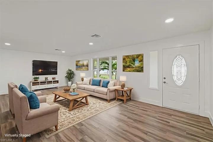 living Bedroom Virtualy staged virtualy staged featuring wood finished floors, ensuite bath, and a ceiling fan