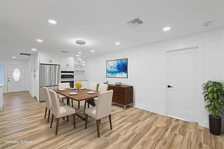 Breakfest area virtualy staged with recessed lighting and light wood-type flooring