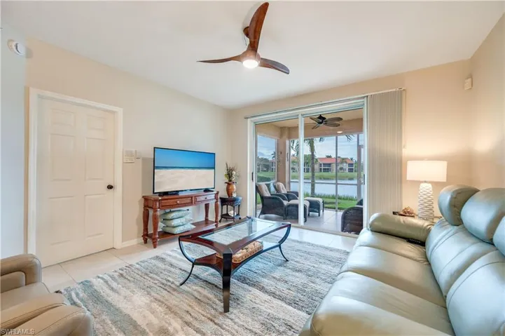 Living area featuring tile patterned flooring and ceiling fan