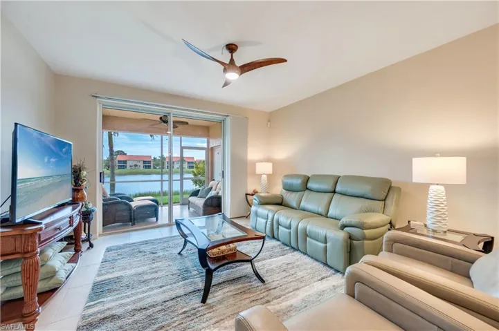 Tiled living area featuring a ceiling fan