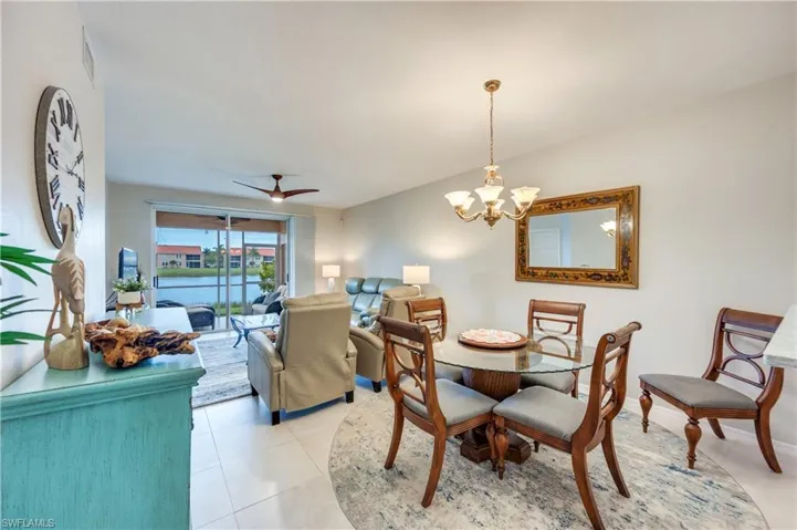 Dining area featuring a ceiling fan, a chandelier, and light tile patterned floors