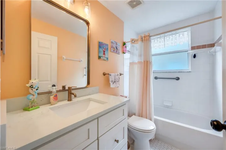 Bathroom featuring shower / bath combo with shower curtain and vanity