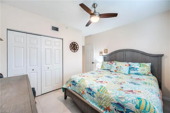 Bedroom featuring ceiling fan, light tile patterned floors, and a closet