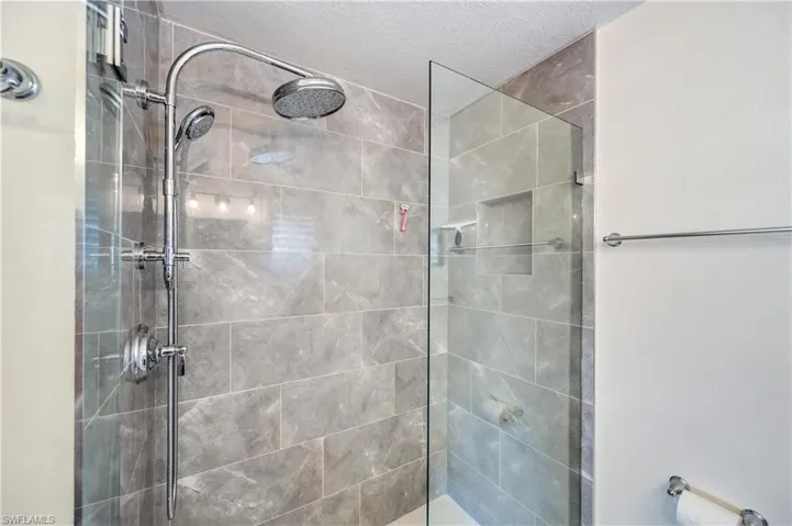 Bathroom with a walk in shower and a textured ceiling