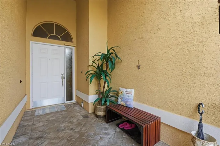 Entryway featuring a paneled white door with an arched transom window and a full-length sidelight