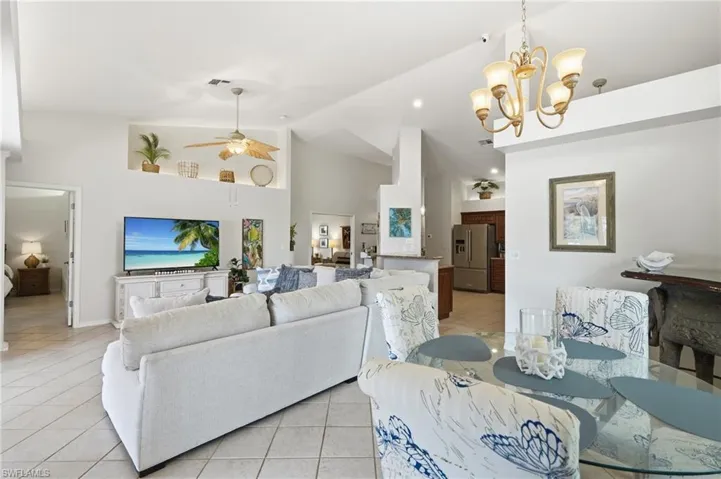 Open-concept living space with vaulted ceilings, recessed lighting, and tile flooring