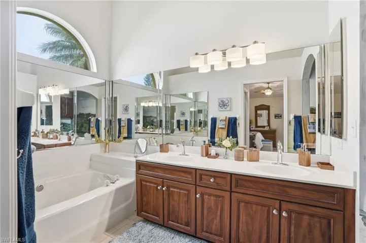 Bathroom featuring a double vanity with wood cabinetry, white countertops, and dual oval sinks
