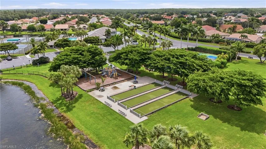 Community recreation area featuring bocce courts, a playground, and lush landscaping