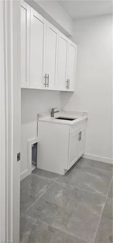 Washroom with light marble finish flooring and baseboards