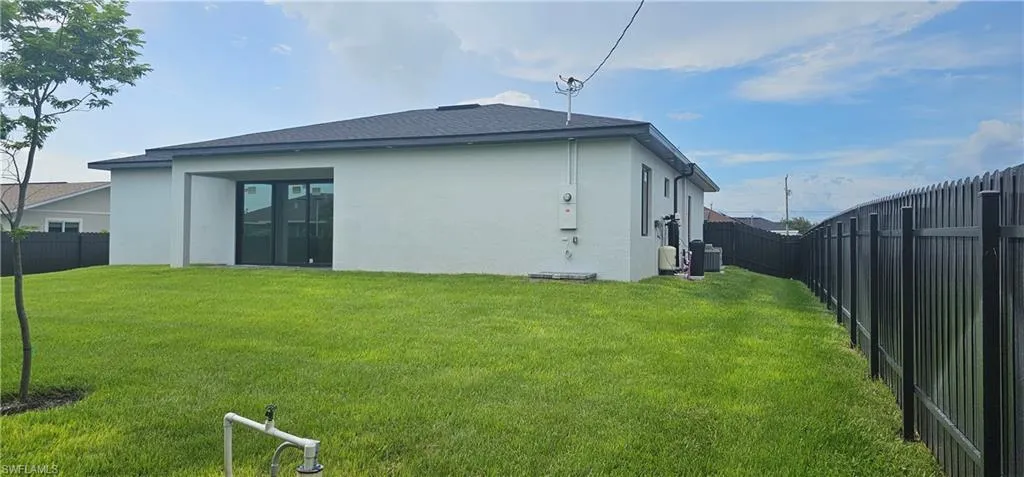 Back of property featuring a fenced backyard, stucco siding, and a shingled roof