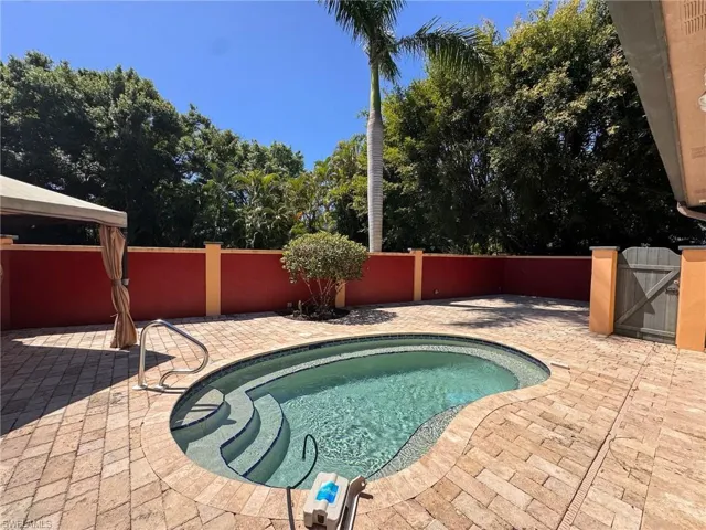 View of dip pool featuring privacy wall, a gate, a patio,