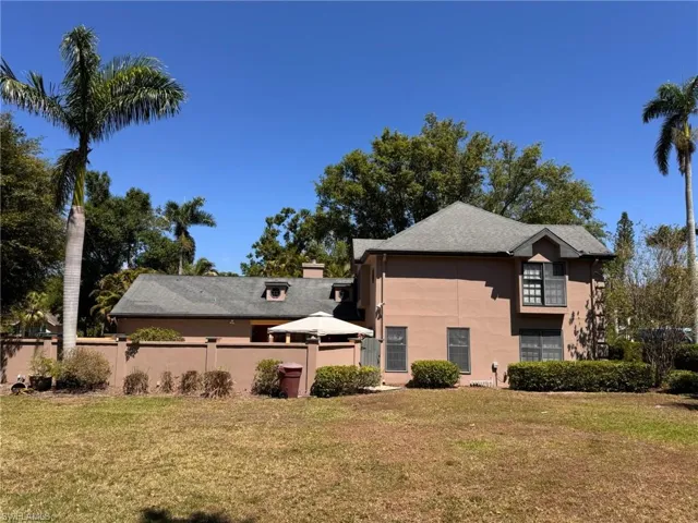 Back of property featuring a large lawn