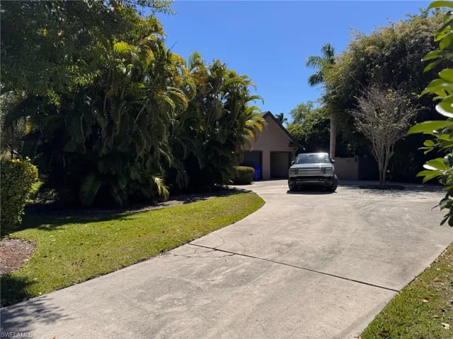 View of front of home featuring driveway, an attached garage, and a front lawn