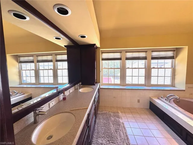 Primary bathroom featuring tile patterned floors, a sink, and plenty of natural light