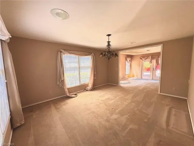Family room with a chandelier, and light colored carpet