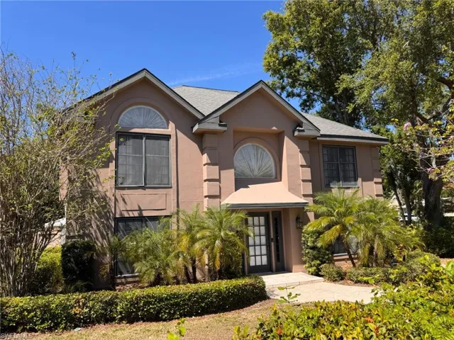 View of front of house featuring stucco siding, a shingled roof, and french doors