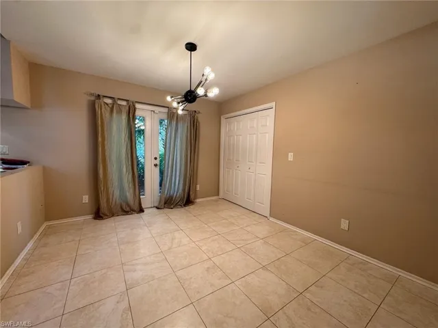 Informal dining room featuring light tile patterned flooring and a chandelier